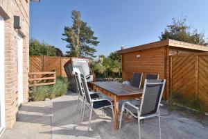 un patio avec une table et des chaises en bois dans l'établissement Lokkich Hüs, à Westerland