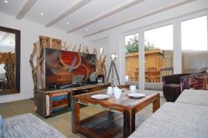 un salon avec une télévision et une table basse dans l'établissement Lokkich Hüs, à Westerland