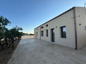 a large white building with a driveway next to it at Sole di Sicilia in Locogrande