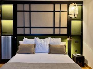 a bedroom with a white bed with a large headboard at Hotel Quinta Solera in Oviedo +37 photos
