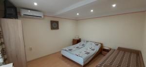 Una pequeña habitación con una cama y un televisor. en Rozika Apartman I, en Hajdúszoboszló 4 fotos más
