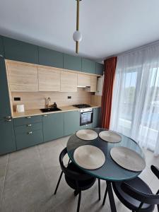 eine Küche mit einem Tisch und vier Stühlen in einem Raum in der Unterkunft Alezzi Odyssey Mamaia Nord II - Parcare Inclusa in Mamaia Nord – Năvodari