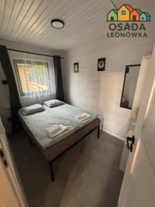 LeonówにあるOsada Leonówkaの部屋にベッドが置かれた小さな寝室