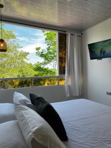 a bedroom with a bed and a large window at Habitación Especial Santorini in Doradal +13 photos