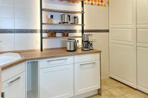 a kitchen with white cabinets and a counter top at Ferienwohnung Am Park mit E-Autoladestation in Lübbenau +15 photos