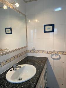 a white bathroom with a sink and a mirror at Casa da Foz do arelho in Nadadouro +14 photos