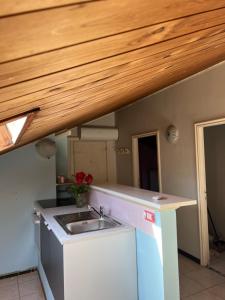 a kitchen with a sink and a wooden ceiling at La Casa dei Pini in Porto San Giorgio