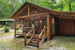 a small log cabin with a porch and a staircase at North 40 Lodge and Cabin in Clarkesville