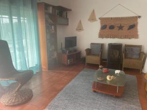 a living room with a couch and a table at Casa da Foz do arelho in Nadadouro