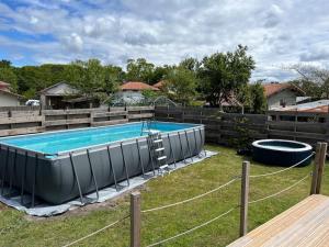 a large swimming pool in a yard with a fence at Villa le Cap in Lit-et-Mixe +12 photos