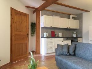 a living room with a blue couch and a kitchen at Heimkehr - ABC302 in Wismar