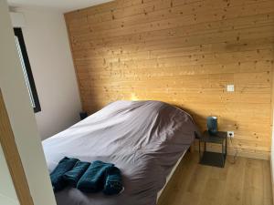 a bed in a room with a wooden wall at Villa le Cap in Lit-et-Mixe