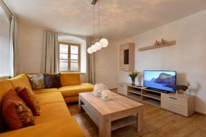 een woonkamer met een bank en een tv bij Jaegerhaus Appartements in Hopfgarten im Brixental