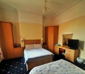 a hotel room with two beds and a television at Manhattan Lodge in Lytham St Annes