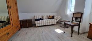 a living room with a couch and a chair at Reethaus "Lütt Dröm" in Zierow
