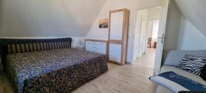 a bedroom with a bed and a mirror and a chair at Reethaus "Lütt Dröm" in Zierow