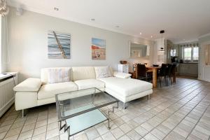 ティンヌムにあるFerienhaus Gartenweg 3bの白いソファとテーブルのあるリビングルーム