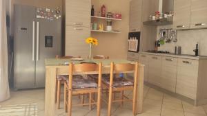 a kitchen with a table with chairs and a refrigerator at Apartment Gaia in Nardò