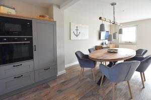 une salle à manger avec une table et une télévision dans l'établissement Ferienhaus Erika, à Tinnum