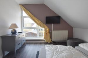 une chambre avec un lit et une grande fenêtre dans l'établissement Ferienhaus Erika, à Tinnum 18 autres photos