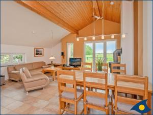 Un comedor y una sala de estar con mesa y sillas. en Ferienhaus Pauline, en Trassenheide