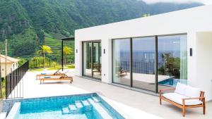 a villa with a pool and a view of the mountains at Elysium by LovelyStay in São Vicente