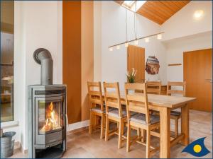 comedor con chimenea, mesa y fogones en Ferienhaus Pauline, en Trassenheide