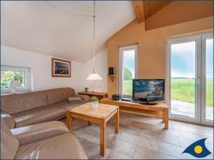 Una sala de estar con un sofá y un televisor. en Ferienhaus Pauline, en Trassenheide 11 fotos más