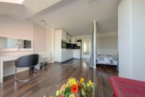 un salon avec un canapé et une table avec des fleurs dans l'établissement Villa Strandidyll Apartment 15, Meerblick, inkl Strandkorb, à Binz