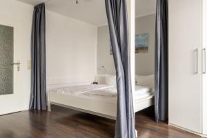 une chambre avec un lit et un miroir dans l'établissement Villa Strandidyll Apartment 15, Meerblick, inkl Strandkorb, à Binz 6 autres photos