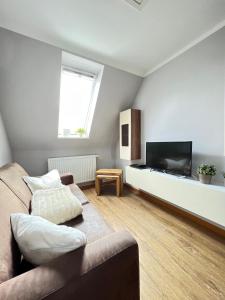a living room with a couch and a flat screen tv at Strandperle in List