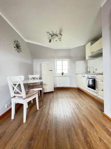 a kitchen with a white refrigerator and a table and chairs at Strandperle in List