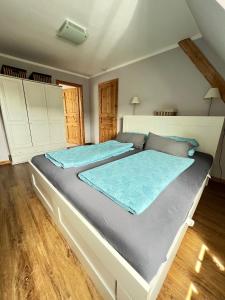 a bedroom with a large bed with blue sheets at Strandperle in List