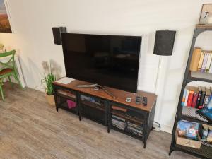 a flat screen tv on a stand in a living room at Walfisch im Zentrum - ABC350 in Wismar