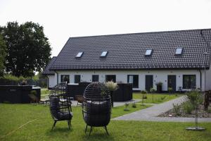 a house with two chairs in the front yard at Rowerowa Przystań in Milicz