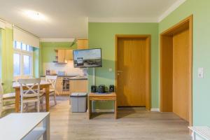 a kitchen and dining room with green walls at Haus Tarnewitz, Ferienwohnung 06 in Tarnewitz