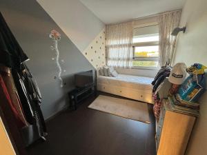 a small bedroom with a bed and a window at Appartement Bouznika Bay Golf Beach in Bouznika +5 photos