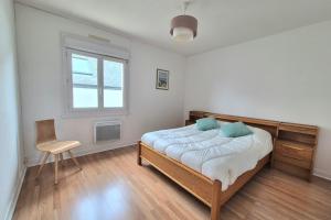 a bedroom with a bed and a chair in it at Large family house - near beach in Lancieux