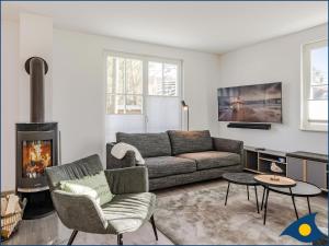 a living room with a couch and a fireplace at Fischerdorf Zirchow Seebär in Zirchow