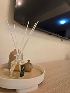 a table with a glass vase with sticks in it at Queen's Escape in Manila