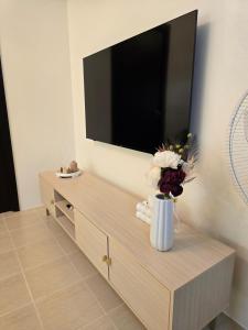 a living room with a flat screen tv on the wall at Queen's Escape in Manila