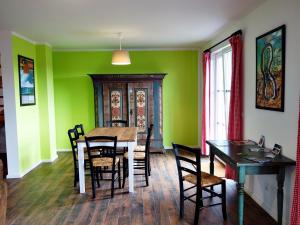 a dining room with green walls and a table and chairs at Zur Fischerwurt 8 in Balm +14 photos