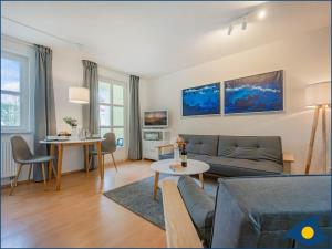 ein Wohnzimmer mit einer Couch und einem Tisch in der Unterkunft Villa Margot Whg 26 in Bansin