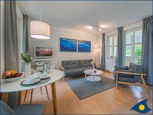 ein Wohnzimmer mit einer Couch und einem Tisch in der Unterkunft Villa Margot Whg 26 in Bansin