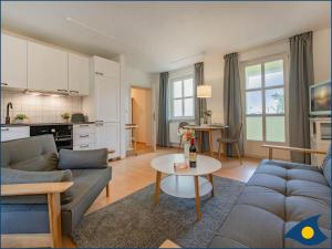 ein Wohnzimmer mit einer Couch und einem Tisch in der Unterkunft Villa Margot Whg 26 in Bansin