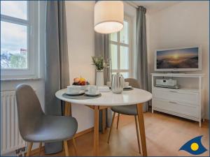 ein Esszimmer mit einem weißen Tisch und Stühlen in der Unterkunft Villa Margot Whg 26 in Bansin