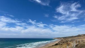 Blick auf einen Strand mit Meer und blauem Himmel in der Unterkunft Bel appartement centre Asilah proche de la mer in Aïn Harrouda
