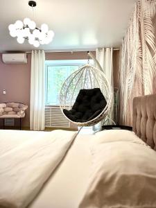 a bedroom with a hanging chair and a bed at 1 кімн квартира ТРоПіКі тихий центр in Chernihiv