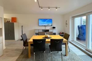 une salle à manger avec une table et des chaises en bois dans l'établissement Ferienhaus Stettiner Str 4b, à Westerland