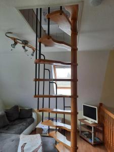 a wooden spiral staircase in a living room with a couch at Ferienhaus LEA in Grabowhöfe +9 photos